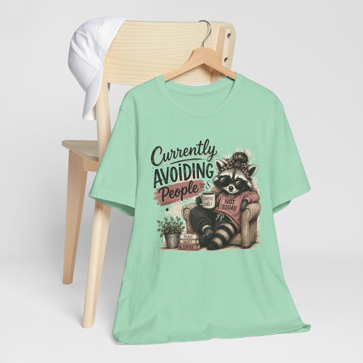 funny tee shirt in mint green with a printed raccoon wearing sunglasses and a headband beside humorous text