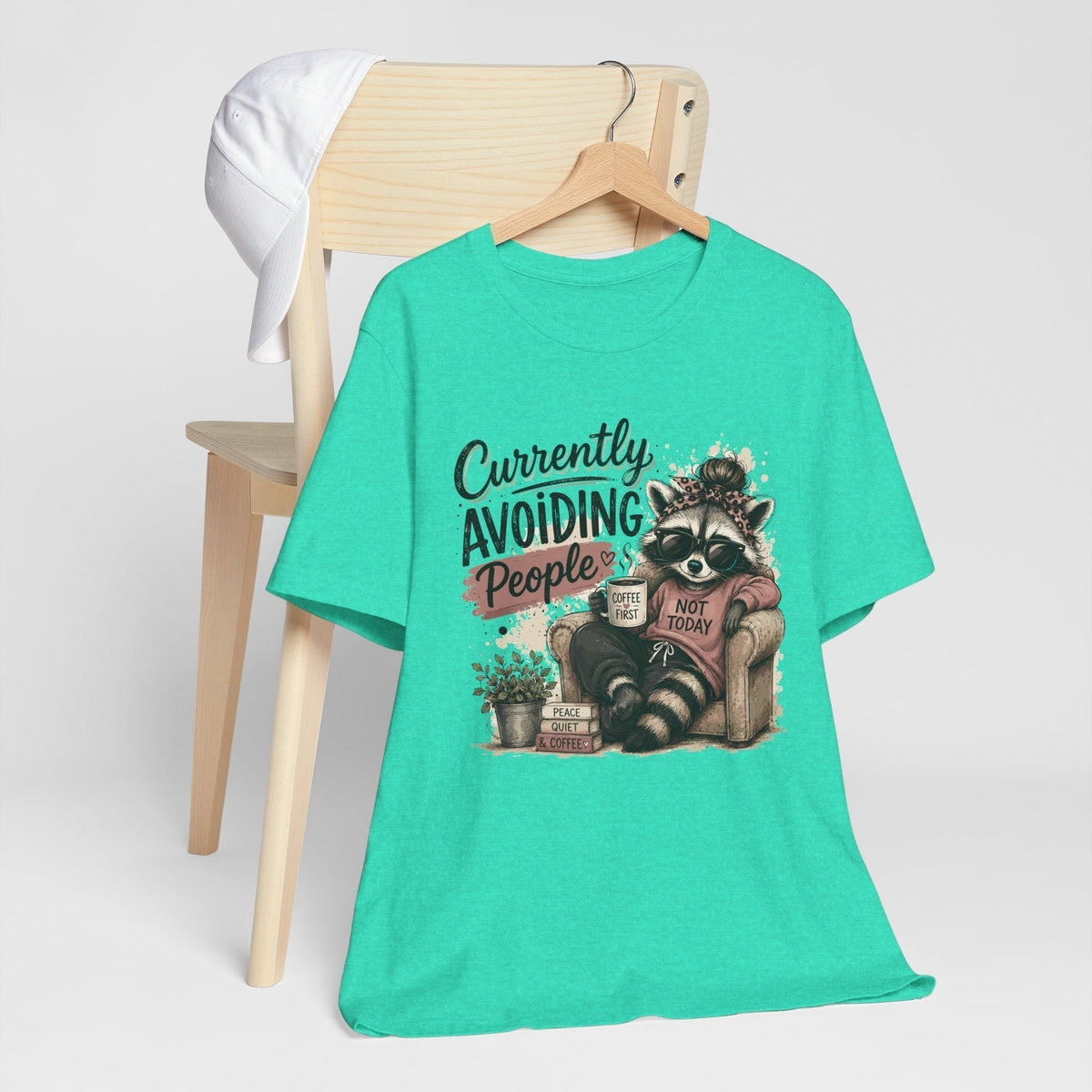 funny tee shirt in bright turquoise cotton with a raccoon graphic, coffee cup, sunglasses and humorous text