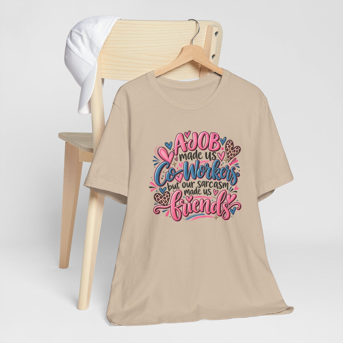 Gift ideas for coworkers beige crew-neck T-shirt with colorful lettering and floral hearts, featuring a sarcastic workplace friendship message