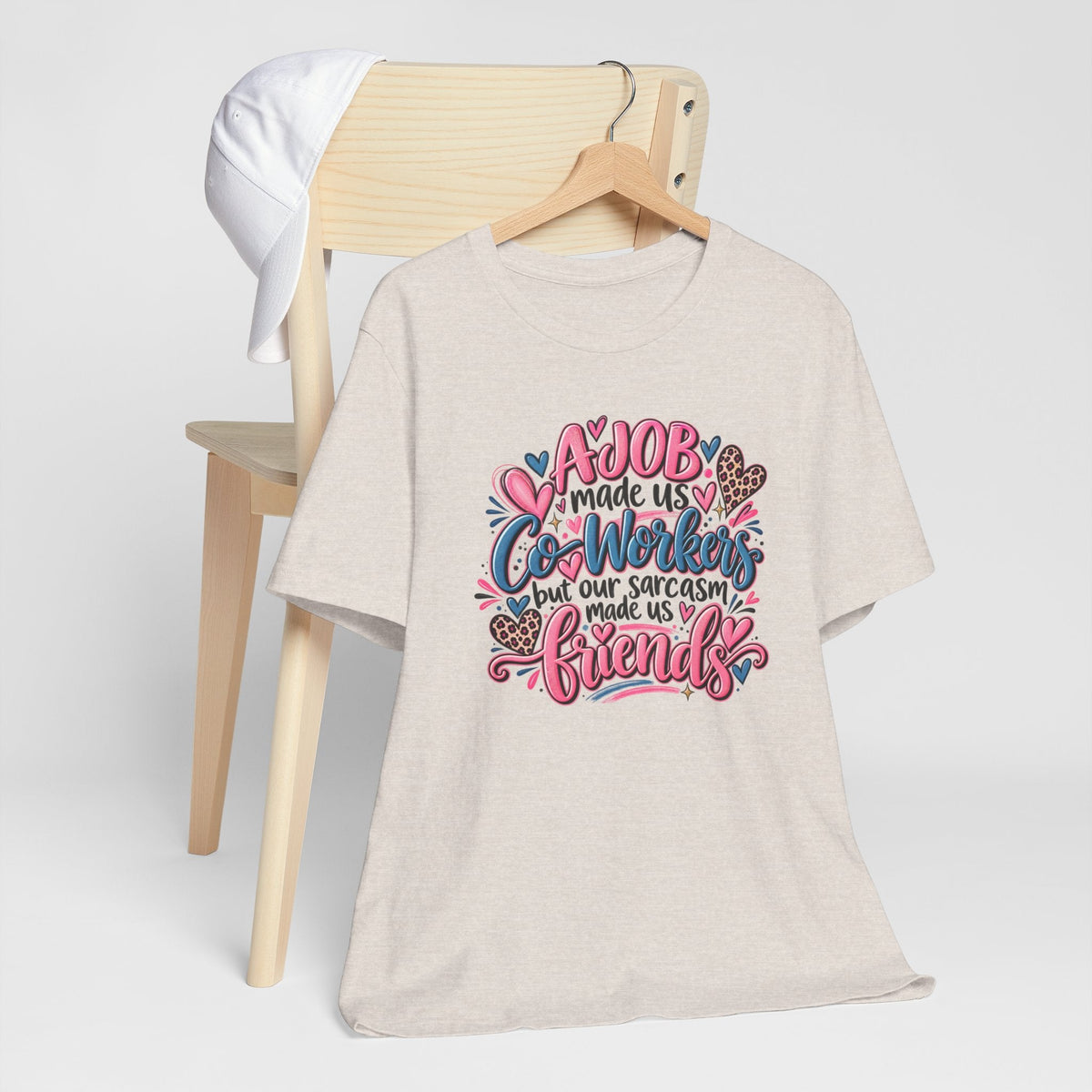 T-shirt in heather beige with colorful “A job made us co-workers” sarcasm and friendship lettering, gift ideas for coworkers