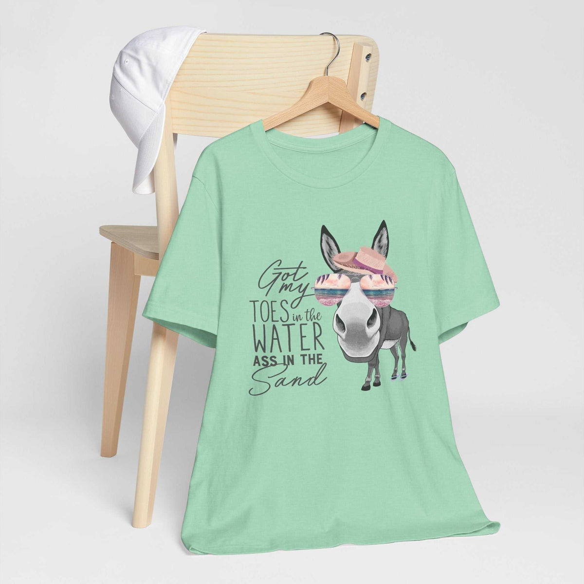 Got My Toes in the Water tee in mint green cotton with a cheeky donkey graphic wearing a pink hat and sunglasses