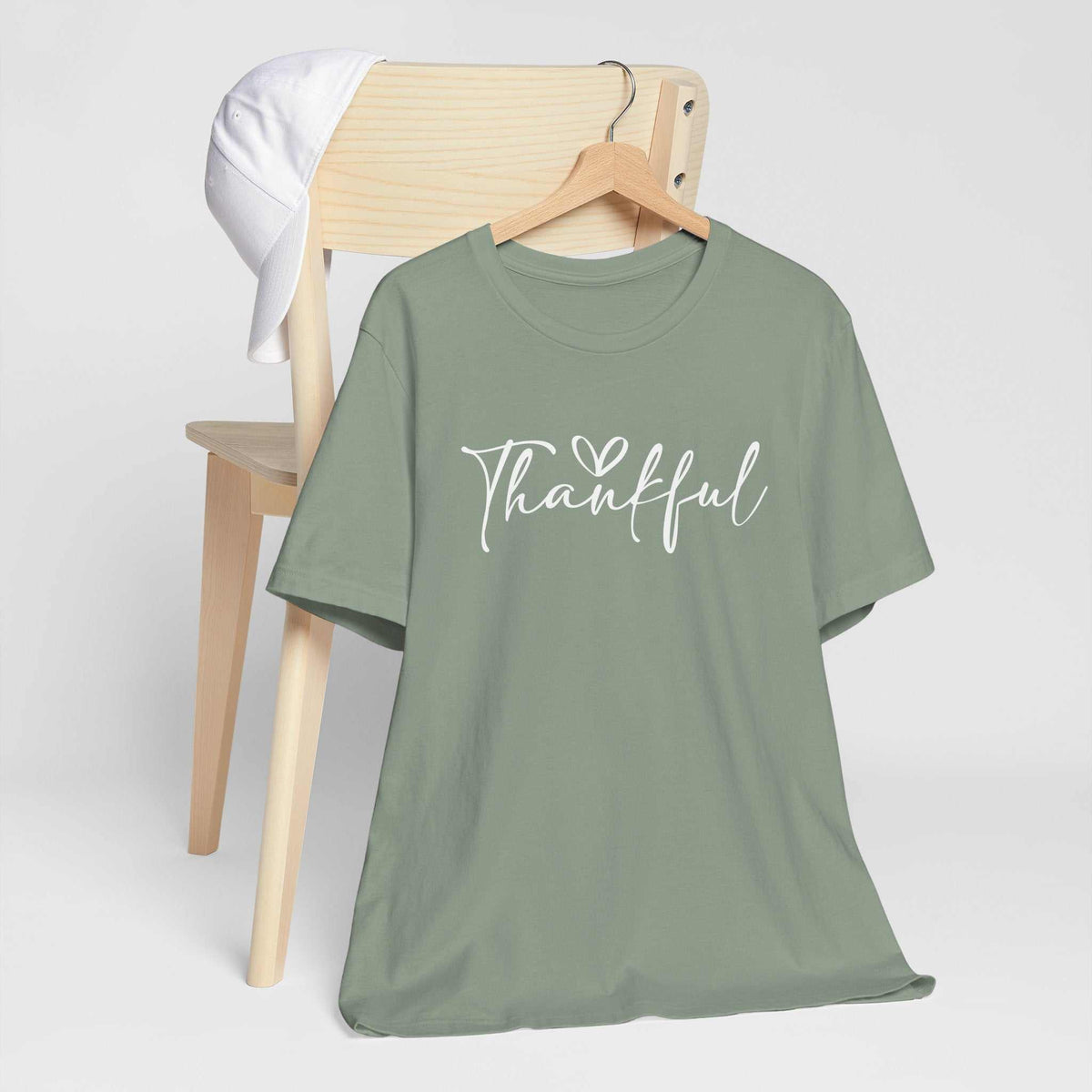 gratitude tshirt in muted sage green cotton with white script lettering reading “Thankful” and a heart