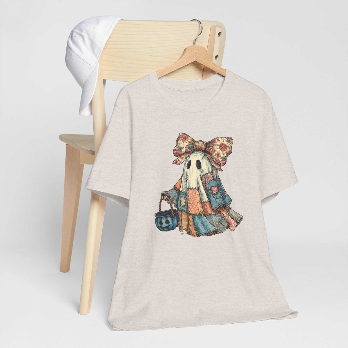 Halloween Ghost Tshirt in cream cotton with a vintage-style ghost in a patchwork dress, floral bow and pumpkin bucket