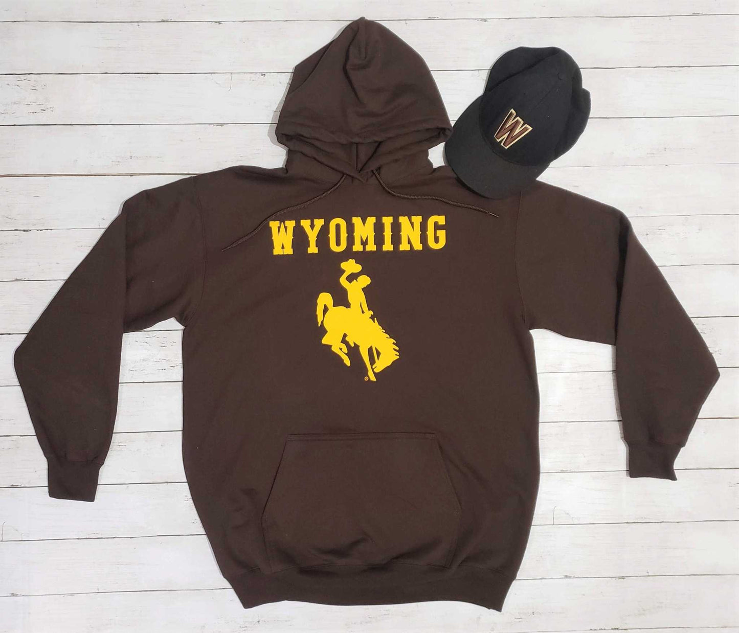 University of Wyoming brown hoodie with yellow bucking horse logo and Wyoming text.