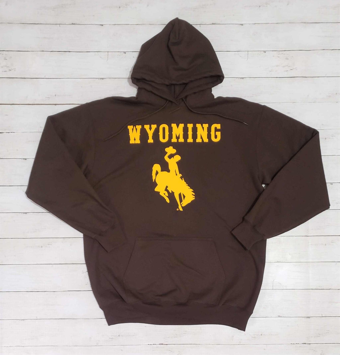 University of Wyoming brown hoodie with gold bucking horse logo and Wyoming text, unisex sweatshirt.