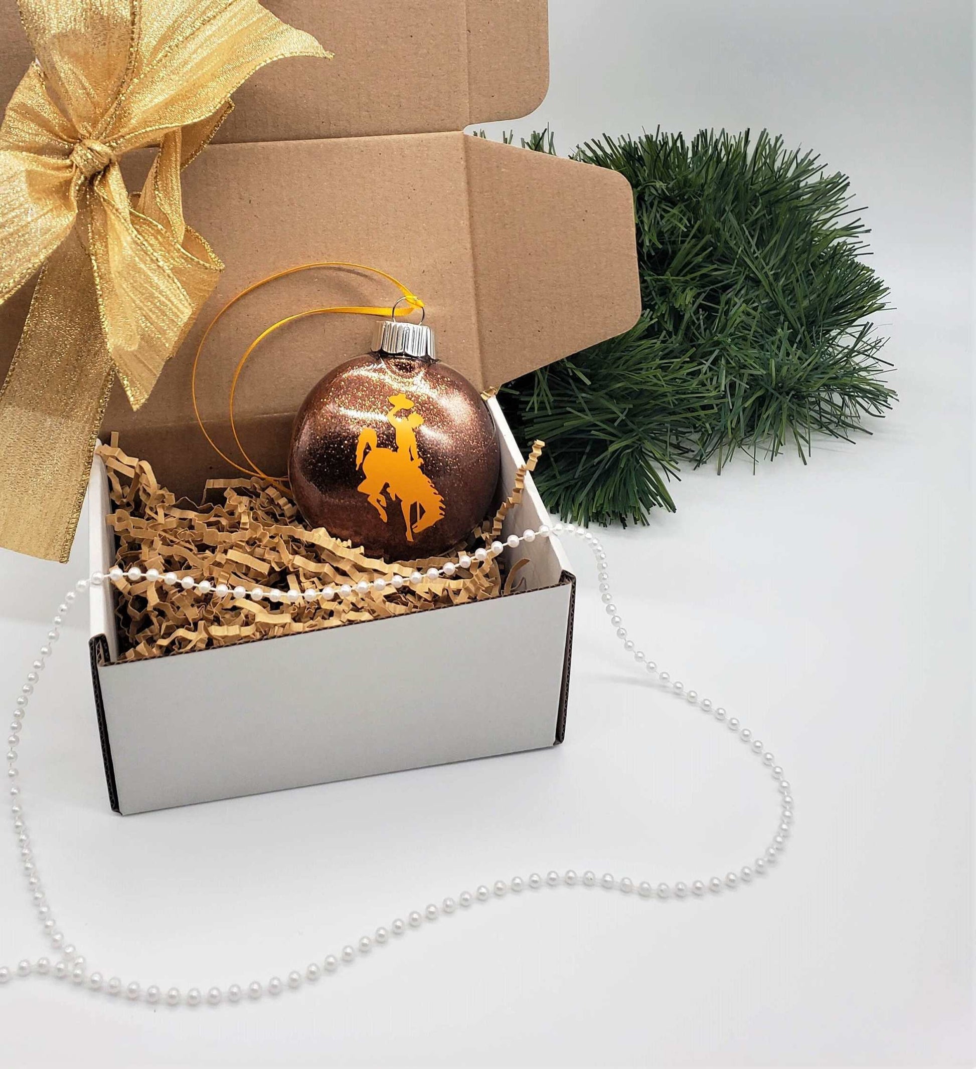 Wyoming Cowboy glitter ornament in gift box with decorative elements.