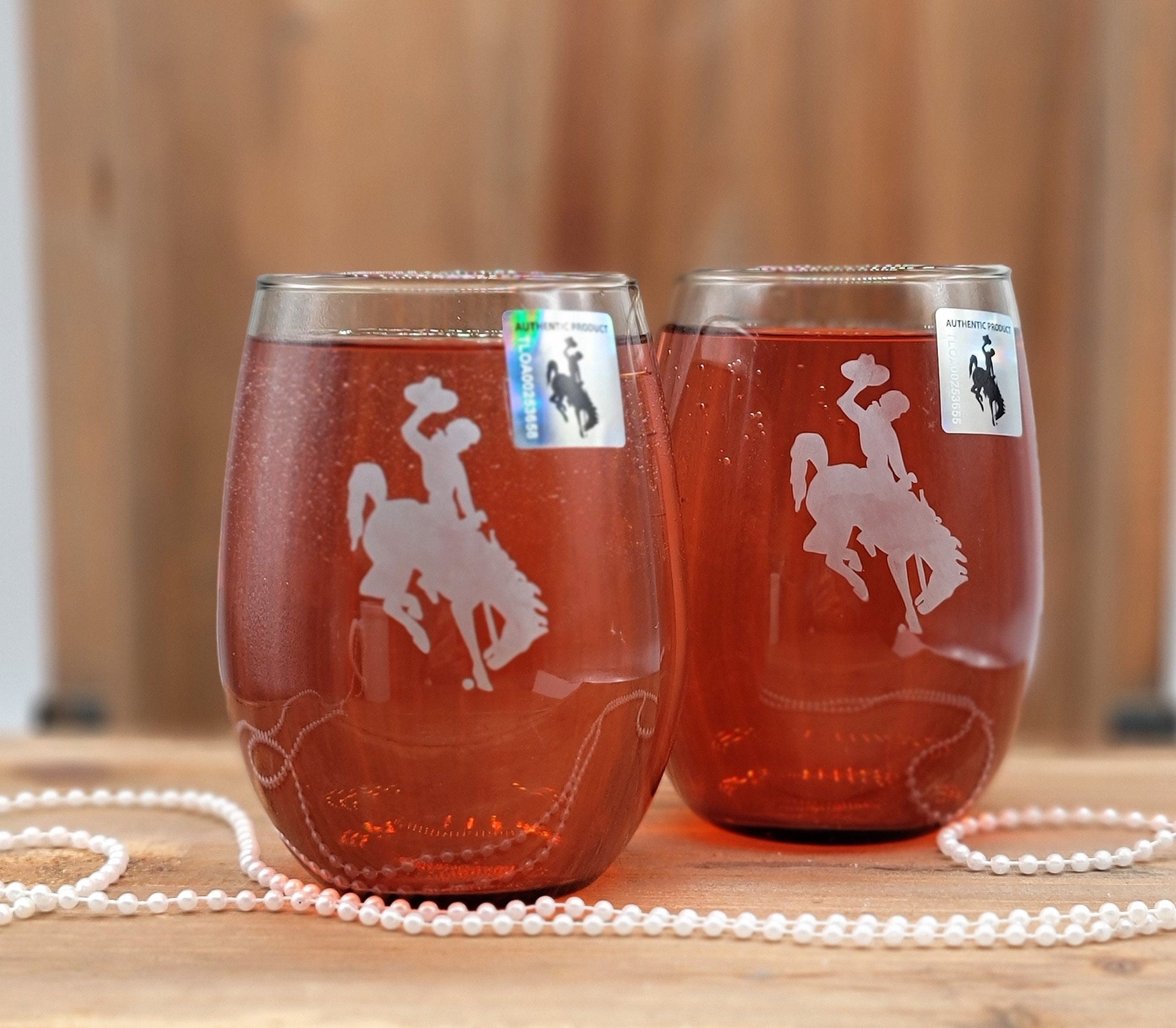 Wyoming Wine Glass Set with etched Bucking Bronco logo, smokey grey finish, and 20.5 oz capacity.