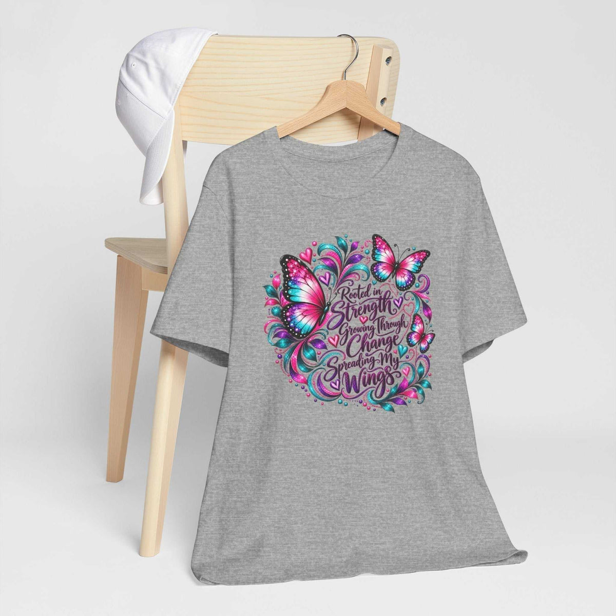 Graphic t-shirt in heather gray with a colorful pink and teal butterfly design and inspirational tshirt design lettering about strength and growth