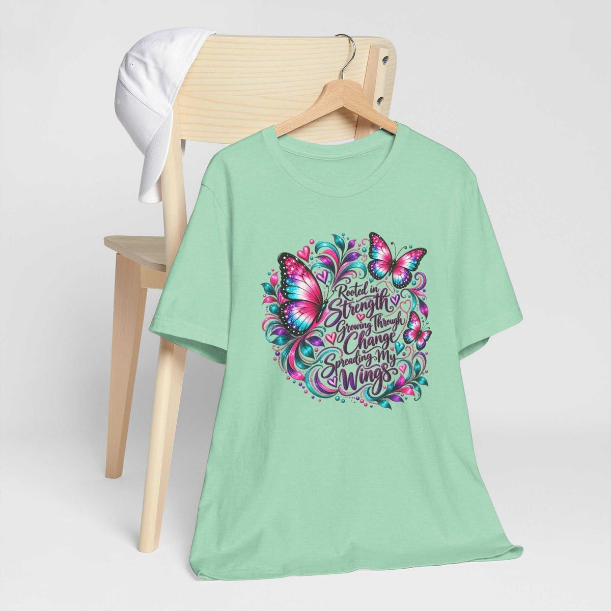 T-shirt in soft mint featuring a colorful butterfly and the message “Rooted in Strength,” an inspirational tshirt design