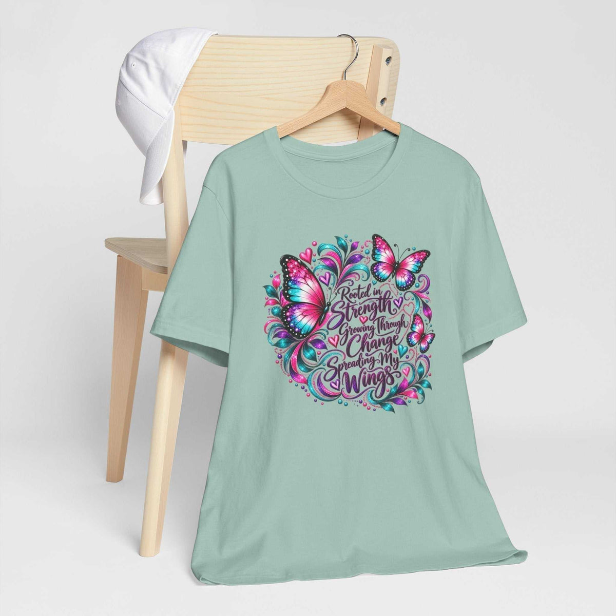 Women's inspirational tshirt design in mint green with a colorful butterfly graphic and message about strength, change and growth