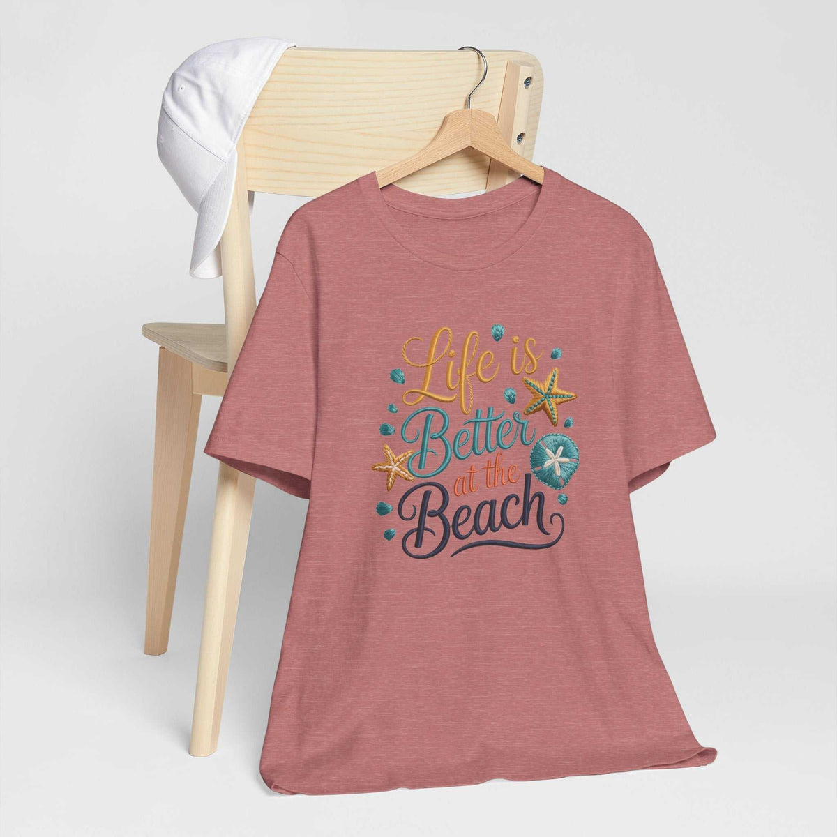 T-shirt in dusty rose heather with a colorful life is better at the beach graphic, seashells and starfish