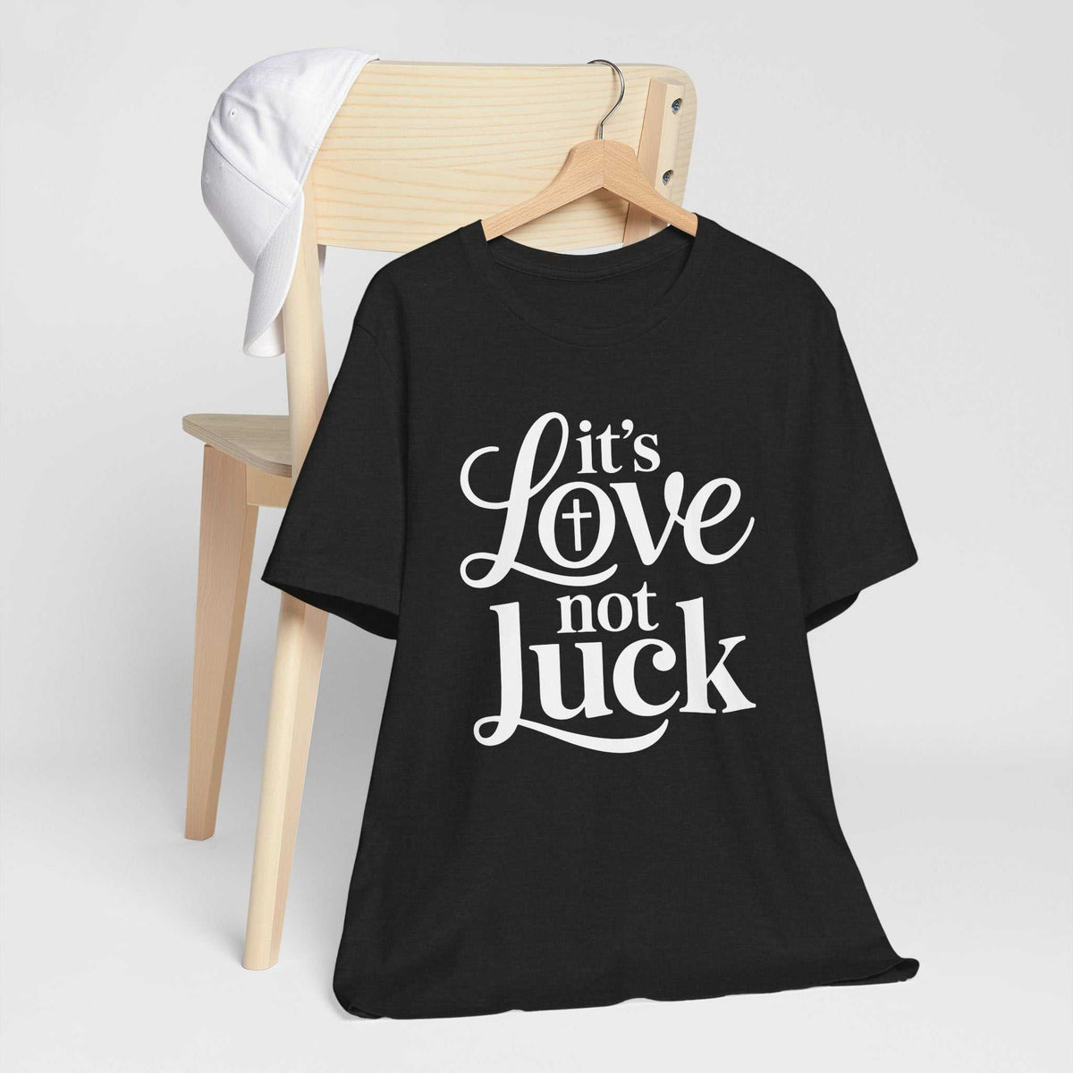 Love in faith shirt, black cotton graphic tee with white script and bold lettering reading “It’s Love not Luck”