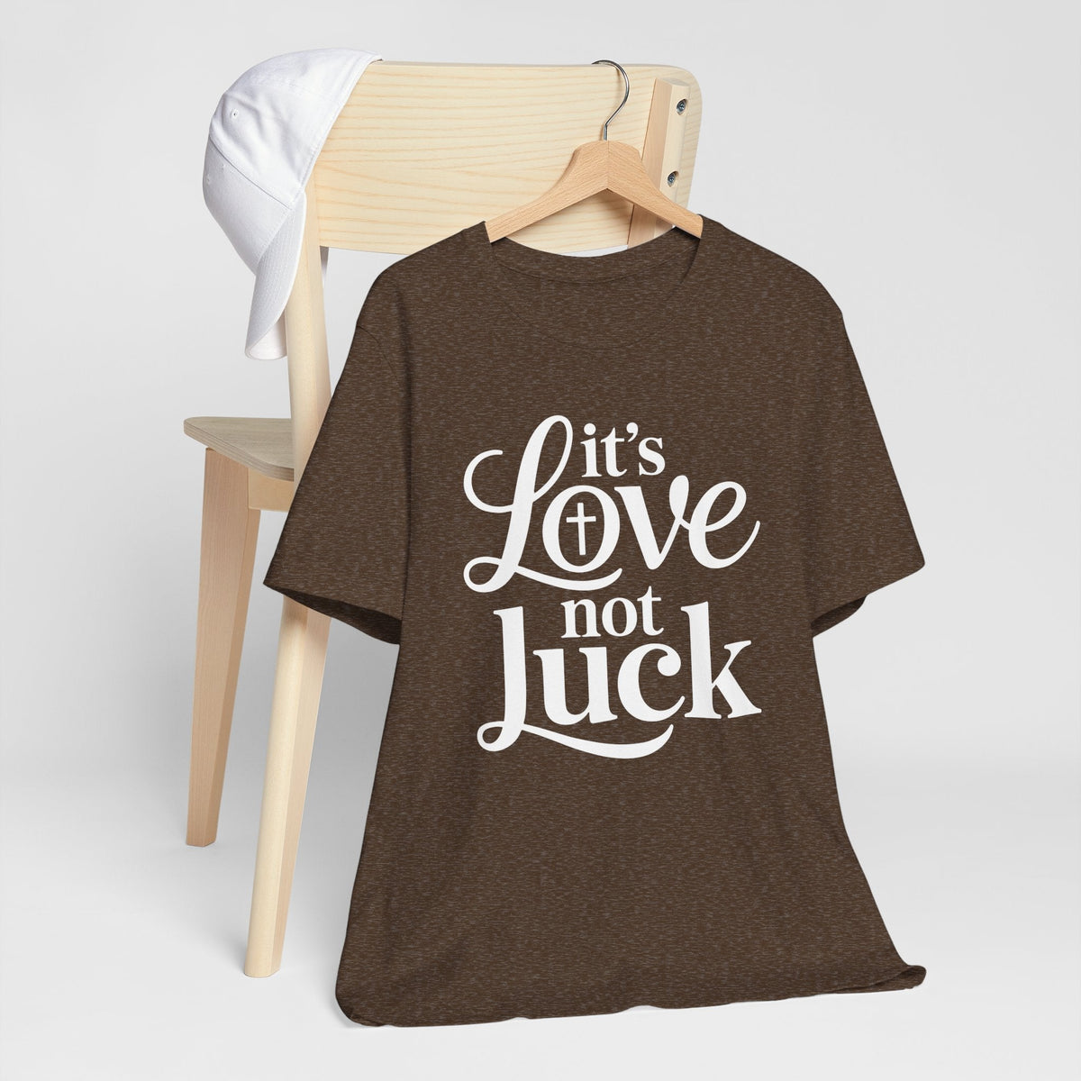 love in faith shirt, dark brown graphic tee with white script and serif lettering reading “It’s Love not Luck”