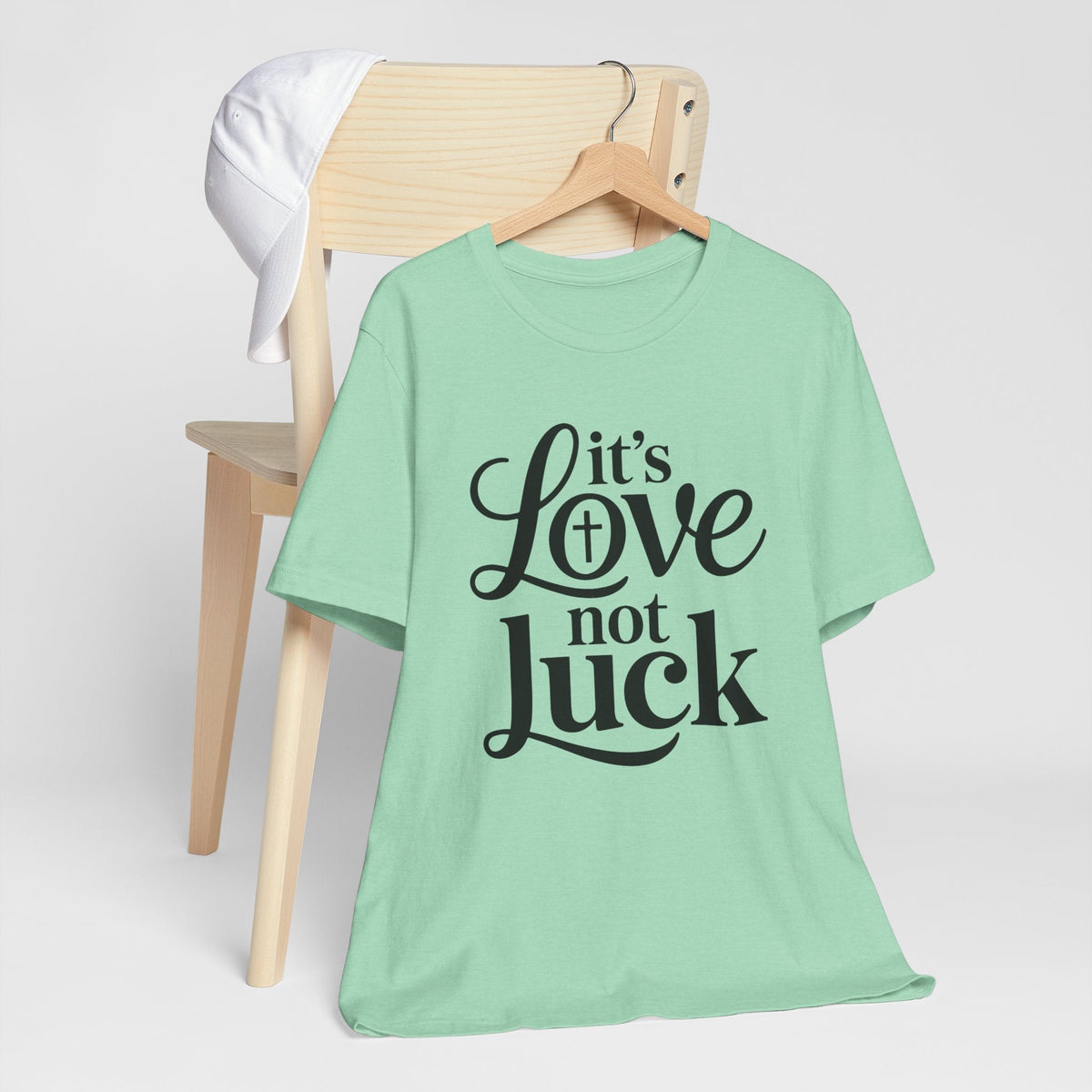 Graphic tee, a mint green cotton shirt with bold black script reading “It’s Love not Luck,” love in faith shirt
