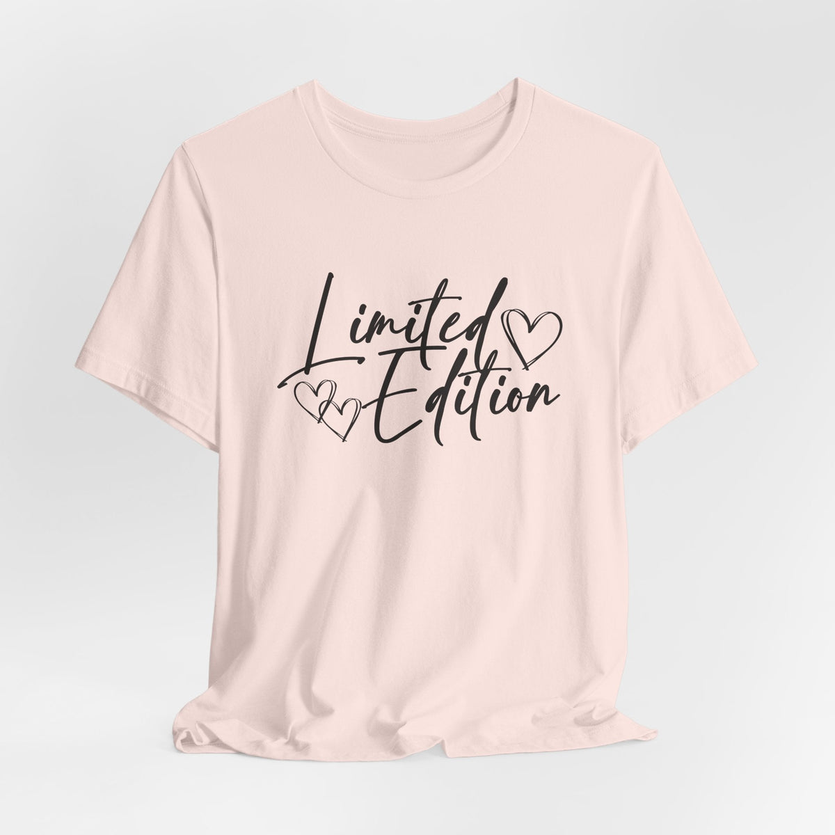 Motivational graphic tee in pale pink with black “Limited Edition” script and delicate heart details across the chest.