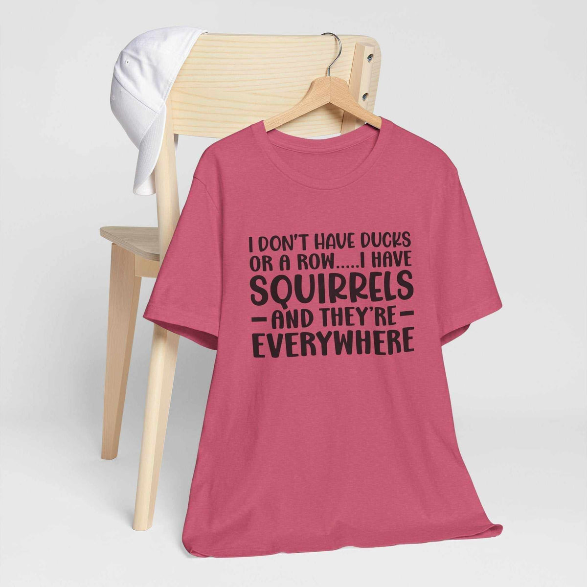 my ducks are not in a row i have squirrels tee in raspberry pink with bold black lettering and playful slogan