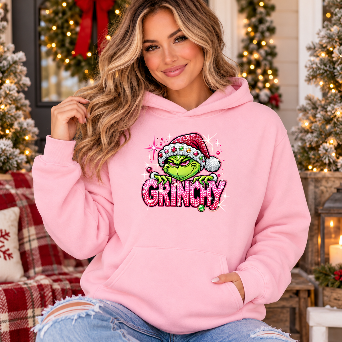 Pink christmas hoodie in soft fleece with a green Grinch wearing a Santa hat above bright pink sparkle-style lettering.