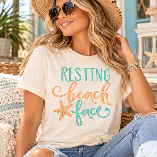 Resting Beach Face T-shirt in cream cotton with turquoise and coral lettering, script accents, and a starfish graphic