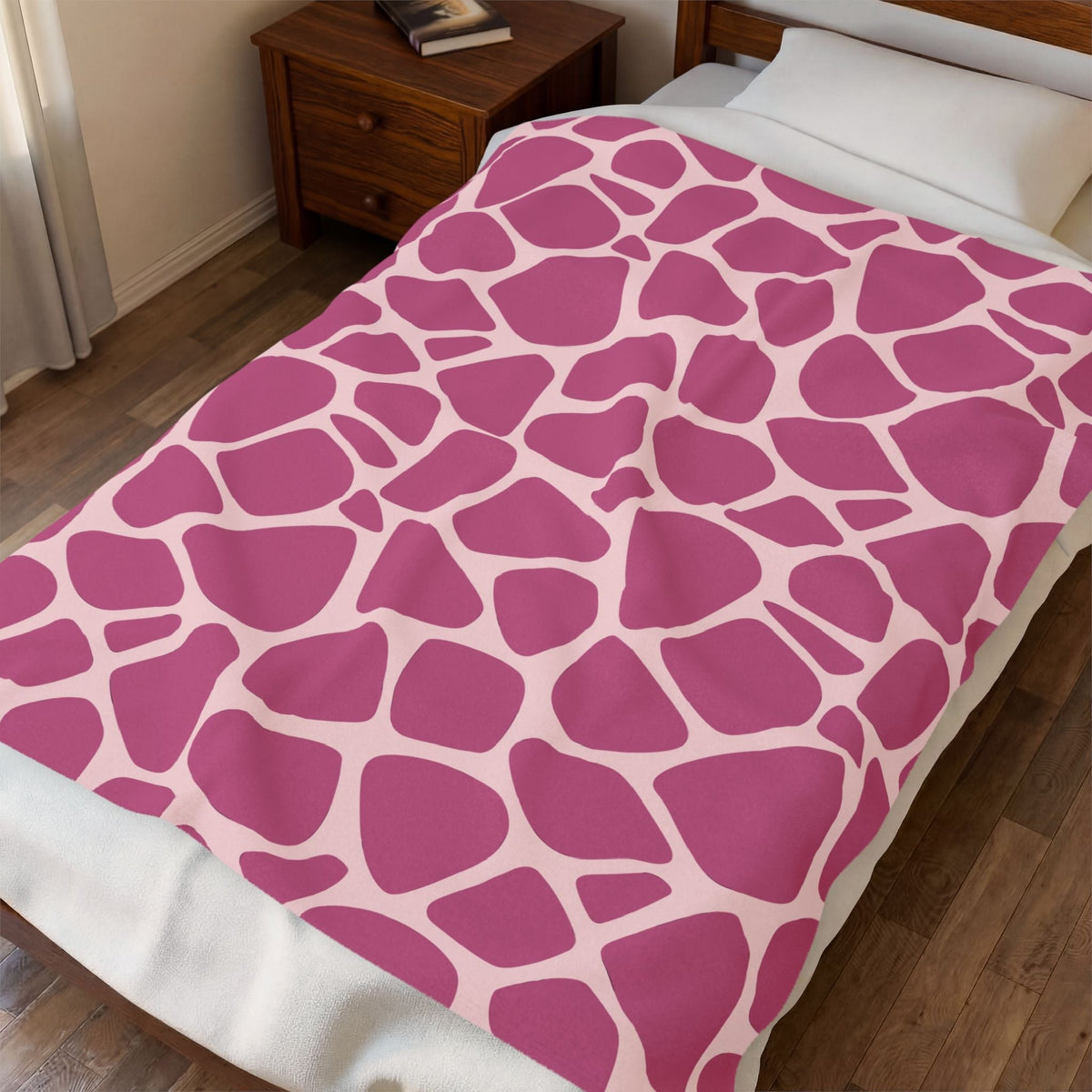 Soft pink throw blanket with bold magenta abstract pebble shapes on a blush background and plush velveteen texture
