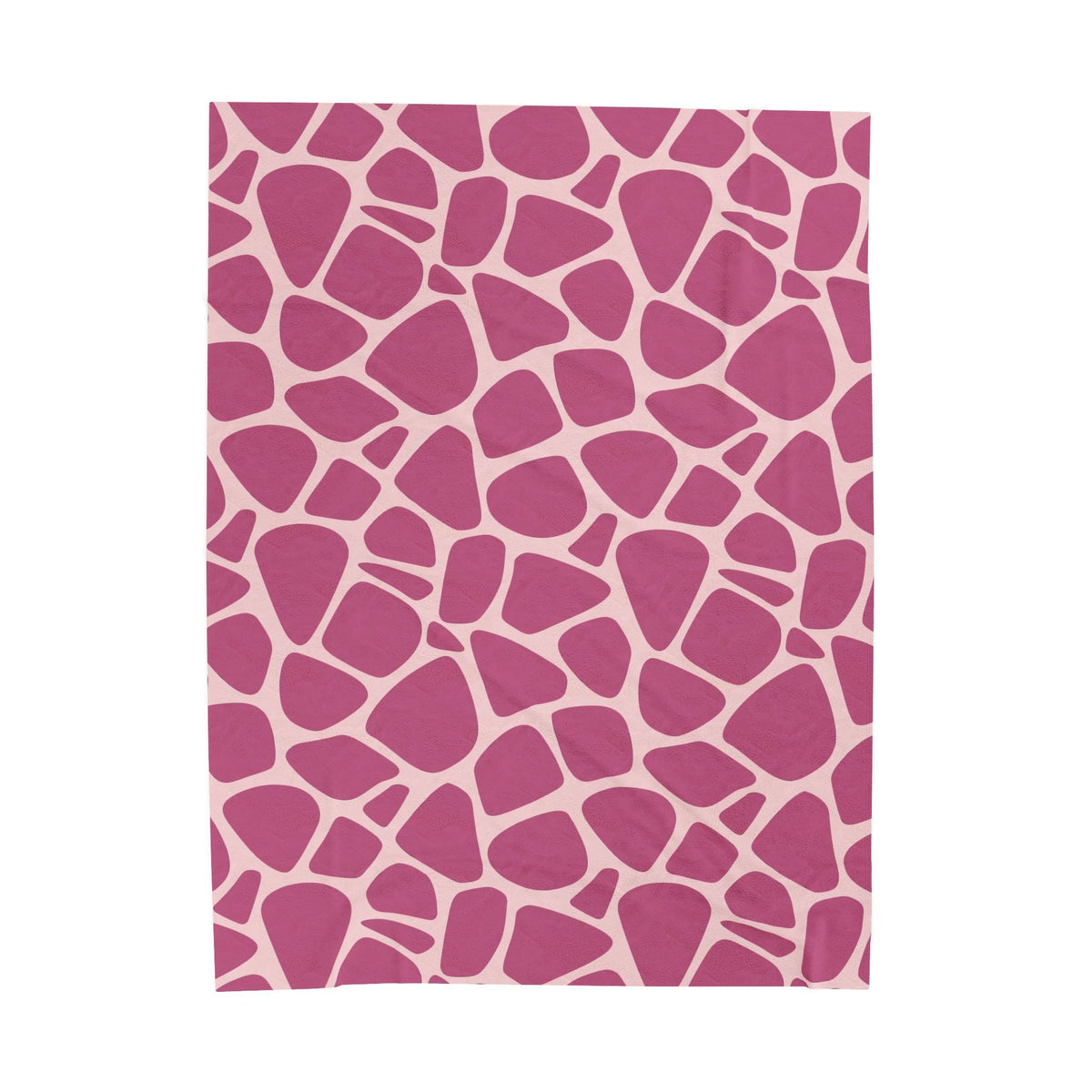 soft pink throw blanket with a velvety plush texture and bold rosy pebble shapes on a pale blush background