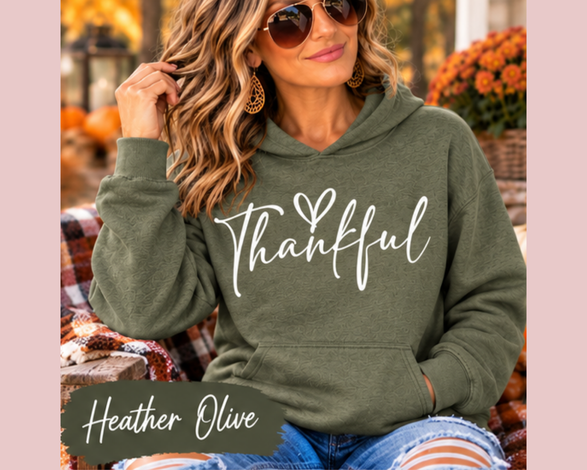 thankful sweatshirt in heather olive with white handwritten lettering and a small heart, featuring a cozy pullover hood