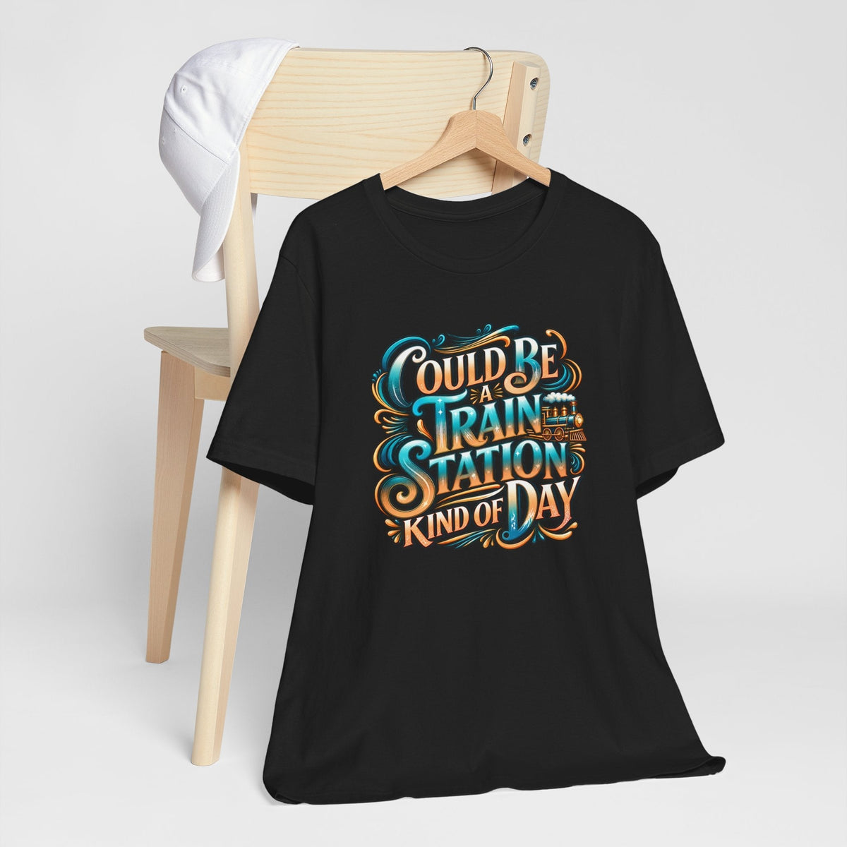 Graphic T-shirt in black cotton reads “Could Be a Train Station Kind of Day” in ornate turquoise and orange lettering with train details.