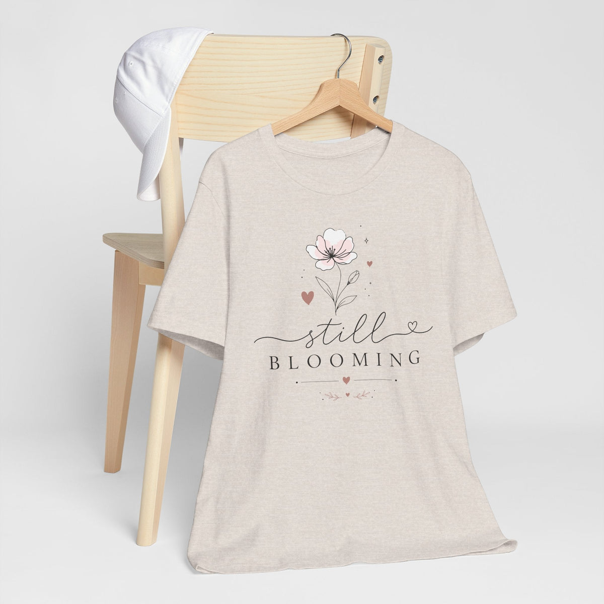 Women's inspirational tshirts: cream cotton tee with a pink floral illustration and elegant “Still Blooming” script
