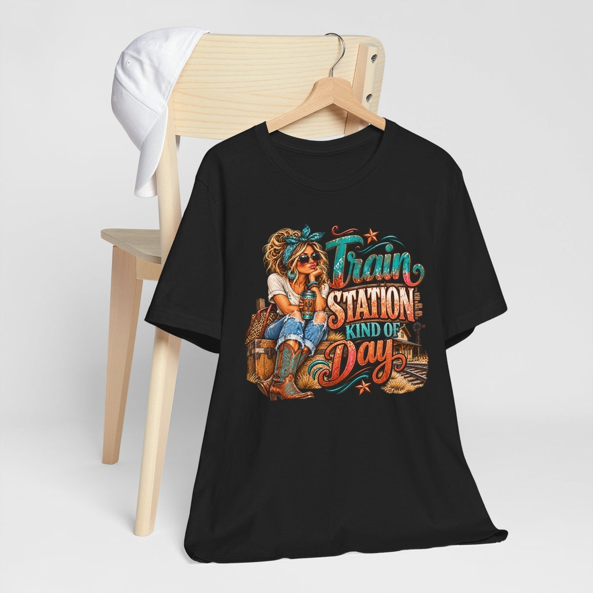 womens western graphic tee in black with a colorful cowgirl, rustic train station scene, and turquoise and rust lettering