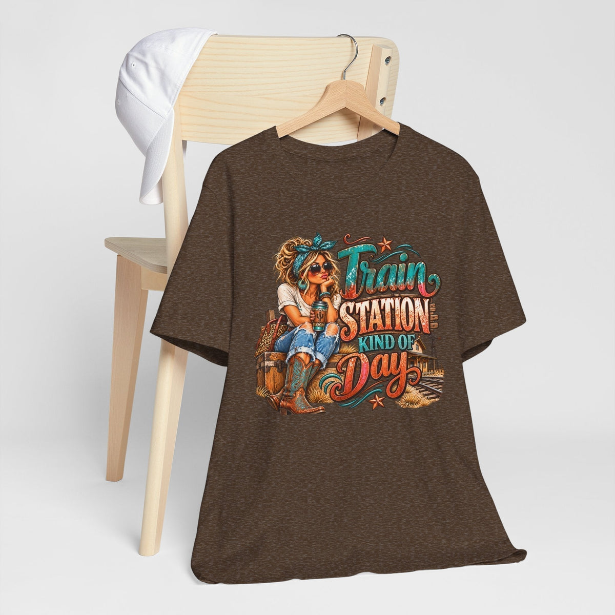 womens western graphic tee in dark brown heather fabric, featuring a colorful cowgirl and railway scene with turquoise and rust lettering