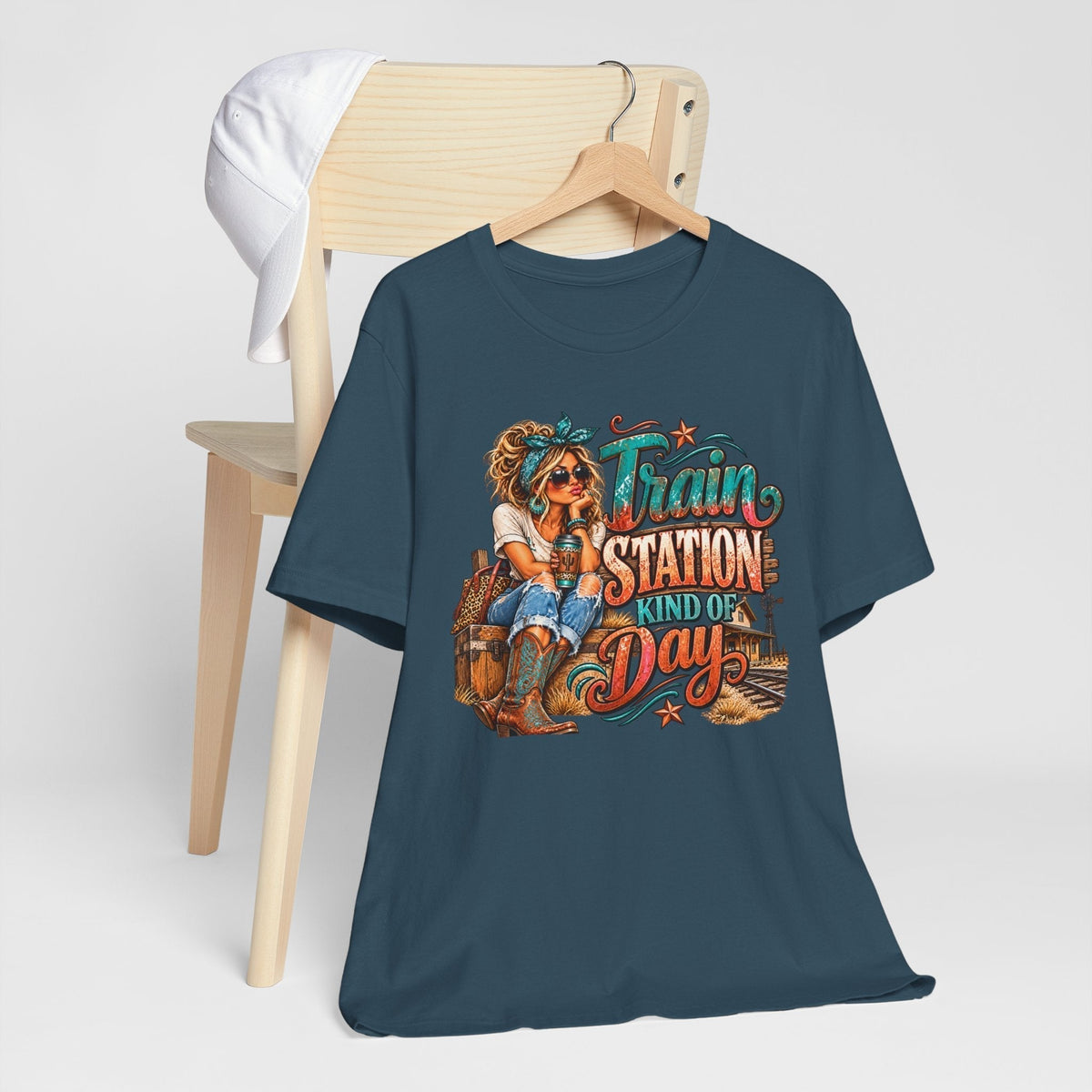 womens western graphic tee in dark teal with a colorful cowgirl, train station lettering, and rustic railway illustration