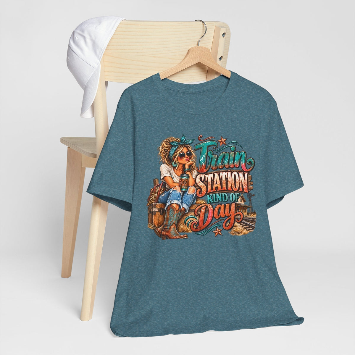 womens western graphic tee in heather blue with a colorful cowgirl, railway scene, and Train Station Kind of Day lettering
