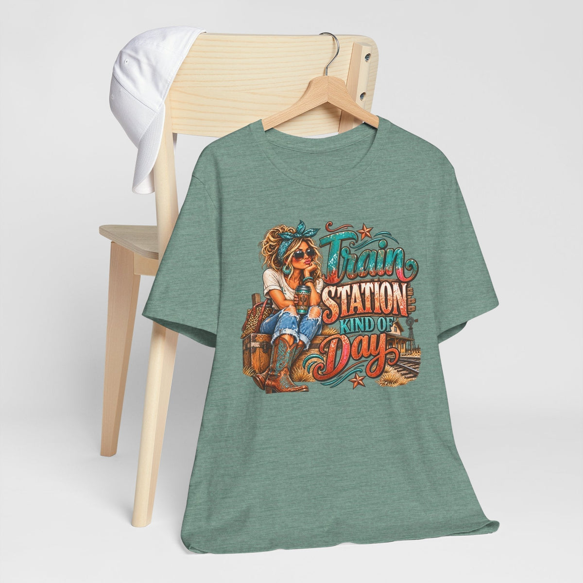 womens western graphic tee in muted teal heather fabric with colorful cowgirl, railway scene, and Train Station Kind of Day lettering